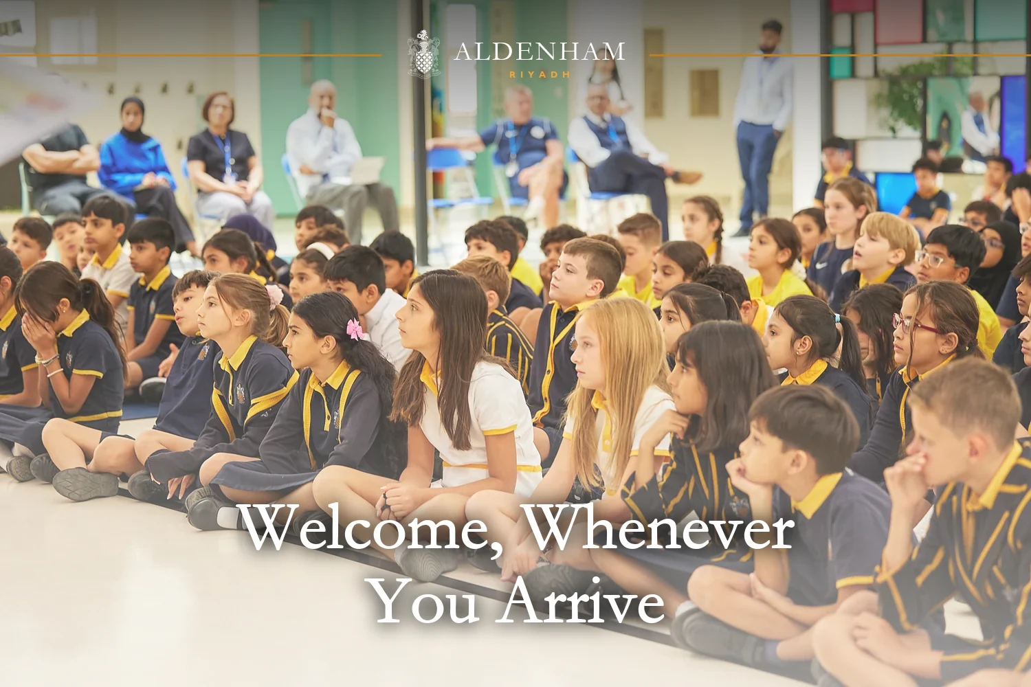 Pupils at Aldenham School Riyadh sitting together and listening at the first-day assembly, with staff behind them